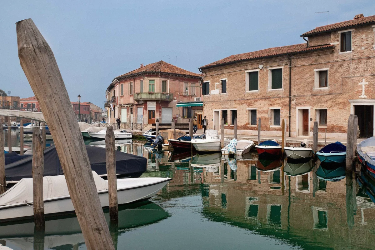 Quiet brick canal on Murano island, the glass island of the Venetian lagoon, contrasted with Burano's painted houses